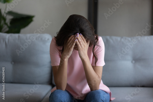 Depressed unhappy young arab mixed race woman feeling hopeless alone at home, suffering from psychological mental problems, relations breakup, betrayal or offend, abortion miscarriage concept. photo