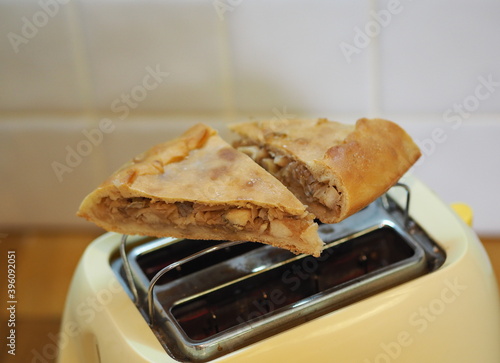 Pieces of pie are warmed up on a toaster for breakfast.Home cooking, healthy natural food.