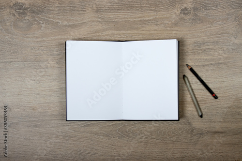Cahier de croquis ouvert avec pages blanches sur fond bois photo