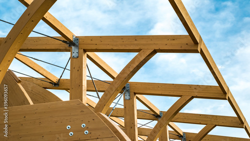 Detail of a modern wooden architecture in glued laminated timber on a blue cloudy sky © Roberto Sorin