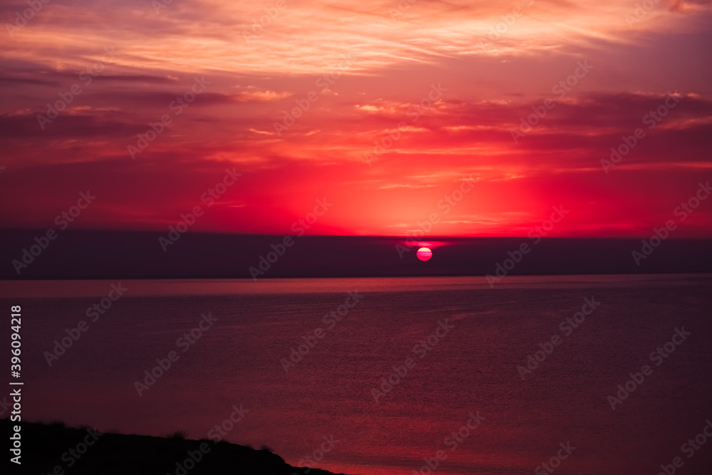 sunset with views of the sea in the Crimea. Red sky and bright lillac sun. The landscape and the beautiful background