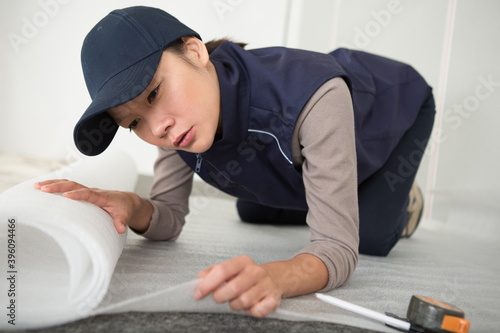 woman fitting roll of underlay to the floor
