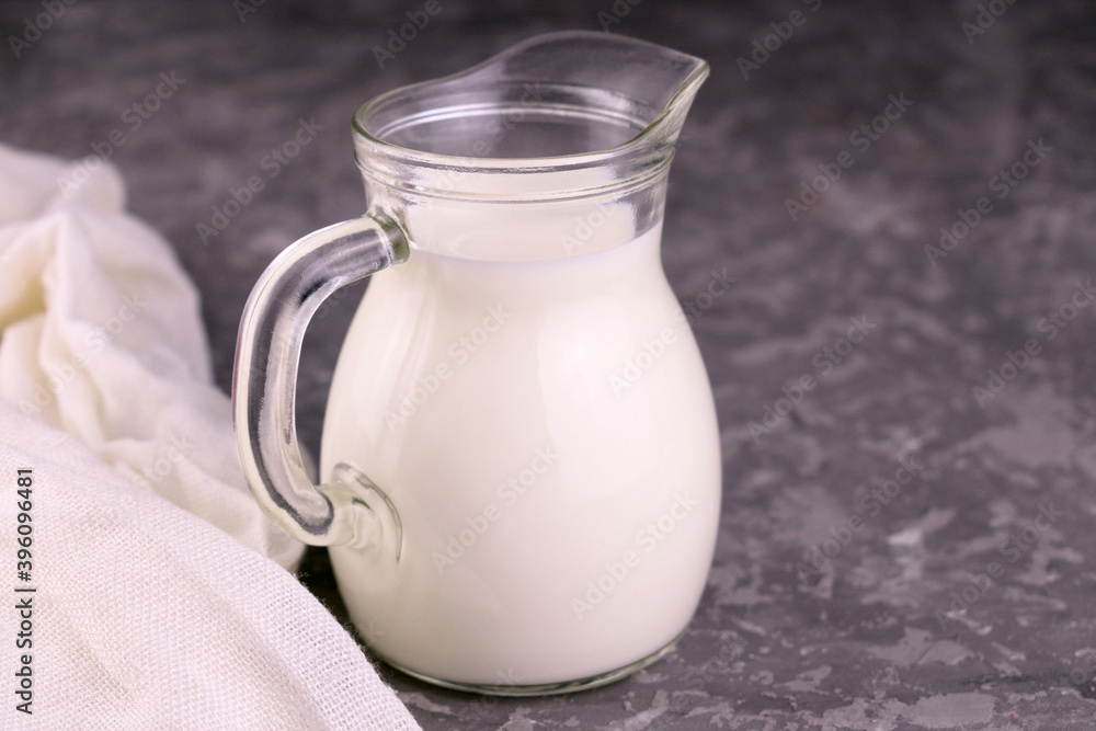 Milk in a decanter on a gray background.Copy space.
Milk in a decanter on a gray background.Copy space.