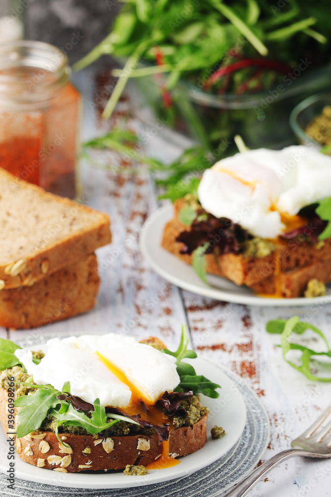 Homemade sandwiches with pesto, green salad and poached eggs Homemade sandwiches with pesto, green salad and poached eggs