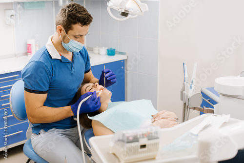A dentist working with patient with dental drill