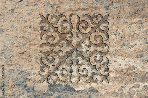 Ornamental print on the stone surface. Vintage ornament on the stone. Embossed drawing. Close-up. Stone texture. Pattern on the stone. Embossed pattern. Wallpaper. Tile