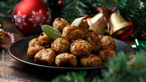 Christmas Pork stuffing meatballs with sage and onion. decoration, gifts, green tree branch on wooden rustic table photo