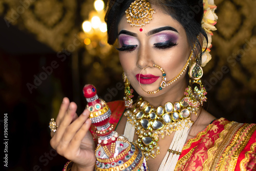 Portrait of very beautiful Indian bride holding traditional wooden sindur or sindoor box in hand. photo
