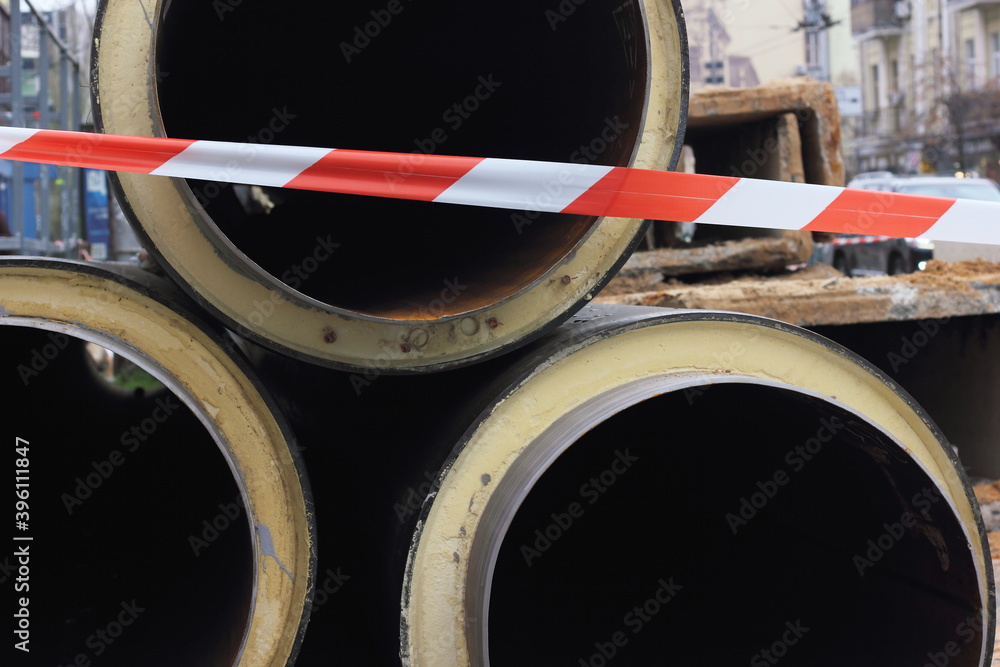 red restrictive tape on the background of trunk pipes red restrictive tape on the background of trunk pipes