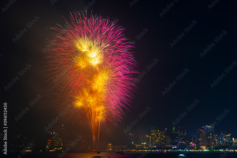 Firework festival with beach foreground and city background at Pattaya beach, Thailand. Colorful firework in celebration festival background Firework festival with beach foreground and city background at Pattaya beach, Thailand. Colorful firework in celebration festival background