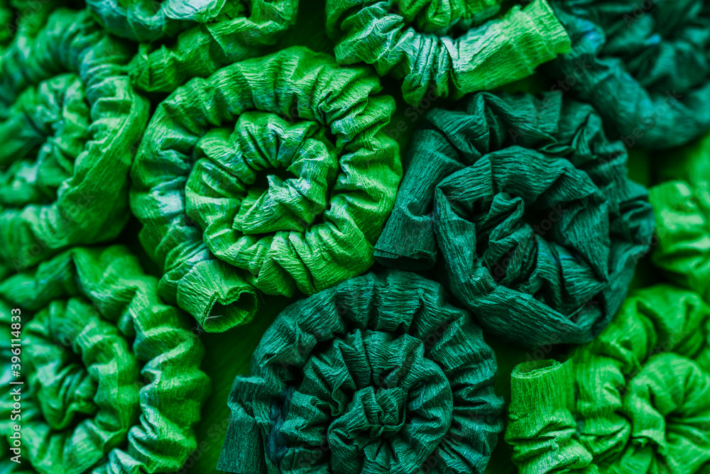 Fototapeta premium Abstract green pattern, background. Ornament from fabric with curls, twisted tubes