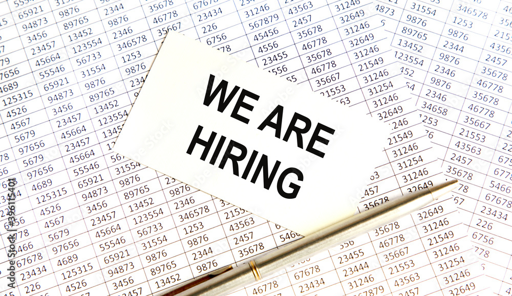 Obraz premium On the card text WE ARE HIRING, amid the reports.