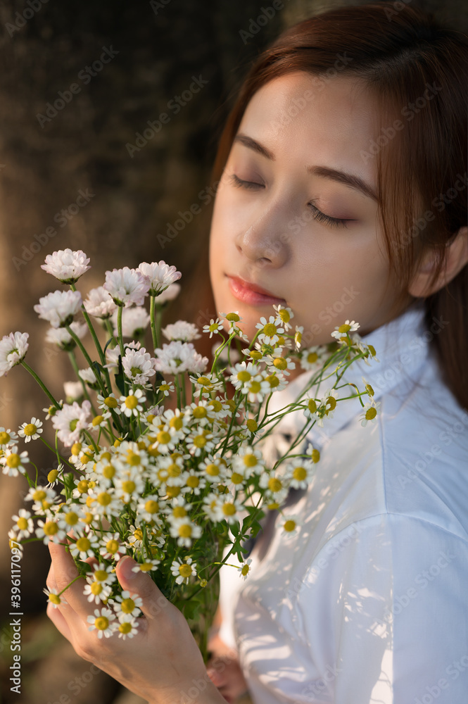 A young woman holds white flowers