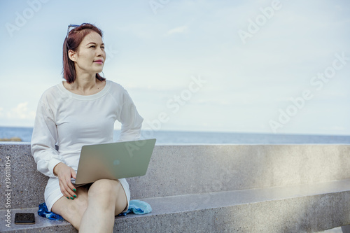 Asian woman using laptop outdoor
