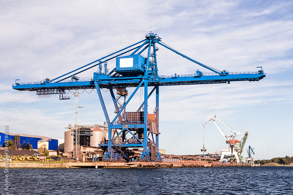 Massive blue crane unload cargo in a seaport in Sweden