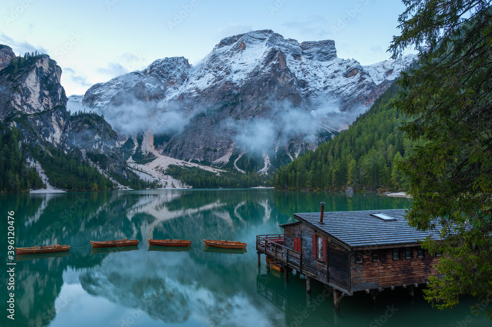 High angle view of iconic boathouse and boats with mount Seekofel mirroring in the clear calm water of Pragser Wildsee (Lago di Braies) in Dolomites, Unesco World Heritage, South Tyrol, Italy