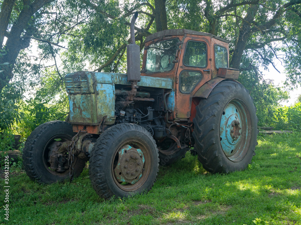 26.07.2020 Russia, Bryansk region. An old rusty dirty tractor is parked in the yard. Non-working rural equipment