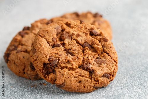 Freshly baked homemade crunchy cookies with chocolate chips, peanut butter or salted caramel. A delicious treat for gourmets. Biscuits close-up. Selective focus, shallow depth of field