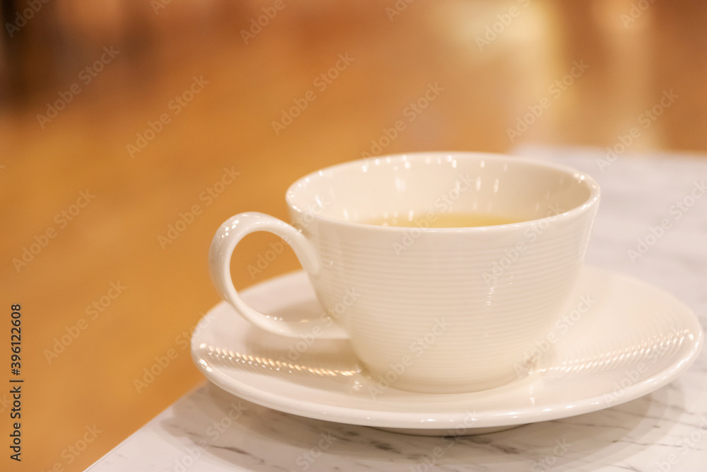 Cup of tea on the table with blur background at cozy cafe and restaurant.