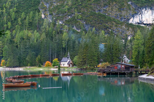 Little chapel at Lake Braies (Pragser Wildsee, Lago di Braies) with boats in foreground. Region of Trentino Alto Adige, Dolomites, Italy