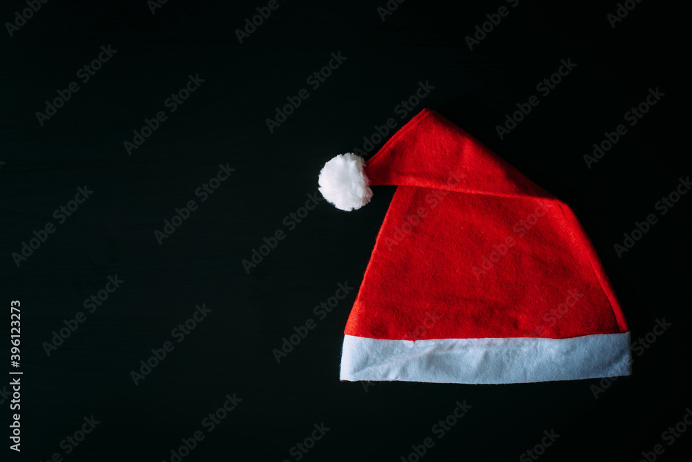 Red Santa Claus hat isolated on black background with copy space. Father Christmas cap, close up. New year concept. Red Santa Claus hat isolated on black background with copy space. Father Christmas cap, close up. New year concept.