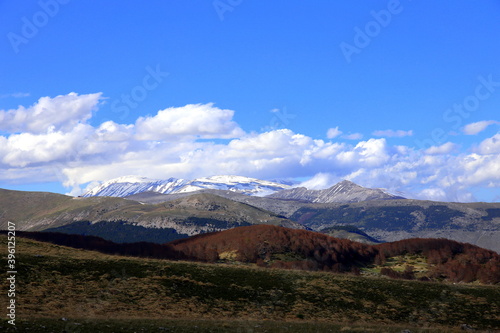 View on series of Apennine mountains with snow and vegetation of different colors, Abruzzo, Italy