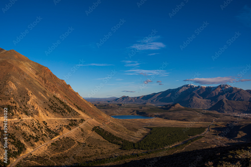 Naklejka premium Winding road heading to La Hoya ski center during sunset in Esquel, Patagonia, Argentina 