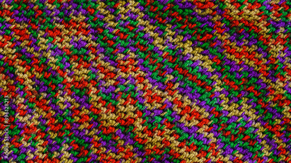 knitted scarf texture. Wool threads of green, purple, yellow, red
