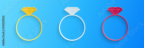 Paper cut Diamond engagement ring icon isolated on blue background. Paper art style. Vector.