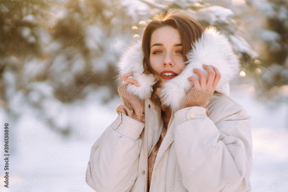 Beautiful woman in winter clothes posing in a snowy park. Young lady walking in a sunny winter day in the forest. Winter fashion, holidays, rest, travel concept. Beautiful woman in winter clothes posing in a snowy park. Young lady walking in a sunny winter day in the forest. Winter fashion, holidays, rest, travel concept.