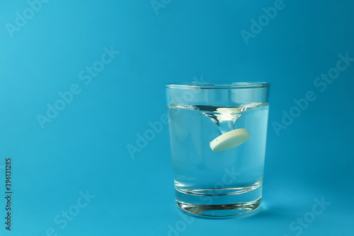 effervescent vitamin C tablet dissolves in water. a glass of water and an effervescent paracetamol tablet. the medicine tablet dissolves in a glass of water