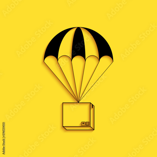 Black Box flying on parachute icon isolated on yellow background. Parcel with parachute for shipping. Delivery service, air shipping concept, bonus. Long shadow style. Vector.