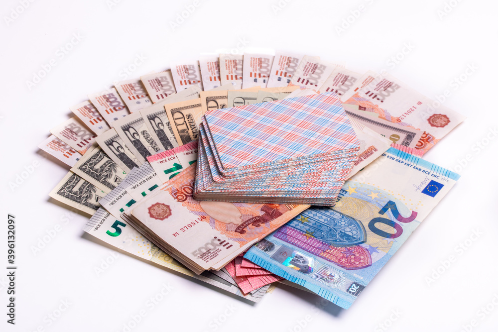 American dollars, euros, rubles and playing cards on top on a white background. Games of chance. American dollars, euros, rubles and playing cards on top on a white background. Games of chance.
