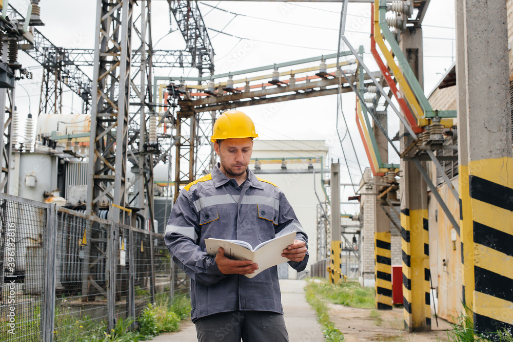 The energy engineer inspects the equipment of the substation. Power engineering. Industry The energy engineer inspects the equipment of the substation. Power engineering. Industry