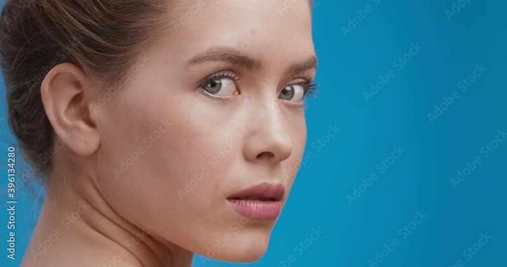 Beauty portrait of gorgeous caucasian lady posing at camera, turning face , blue studio background Beauty portrait of gorgeous caucasian lady posing at camera, turning face , blue studio background