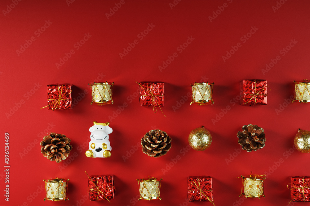 Christmas decorations and a toy cow on a red background. Christmas decorations and a toy cow on a red background.