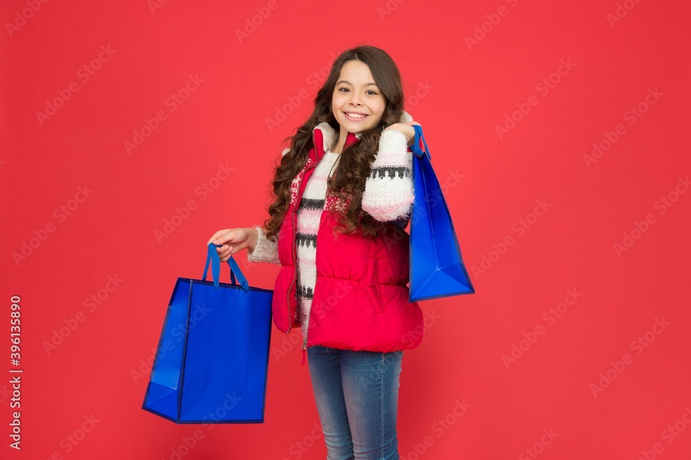 happy teen girl in warm winter clothing carry shopping bags with gifts for christmas holiday, christmas sales