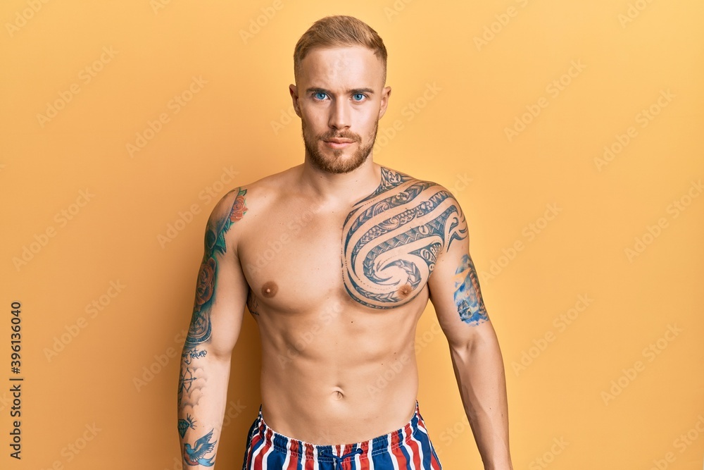 Fototapeta premium Young caucasian man wearing swimwear shirtless skeptic and nervous, frowning upset because of problem. negative person.