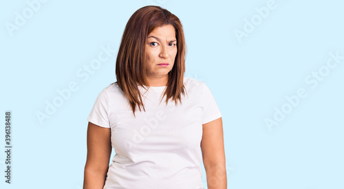 Middle age latin woman wearing casual white tshirt skeptic and nervous, frowning upset because of problem. negative person.