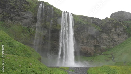 Base view of Seljalandsfoss waterfall in southern Iceland, drop of 60m,  Handheld tilt up shot photo