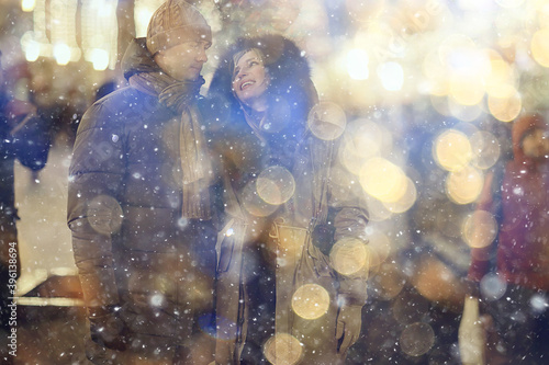 couple in love on a christmas walk in the city, evening snowfall december holiday new year © kichigin19