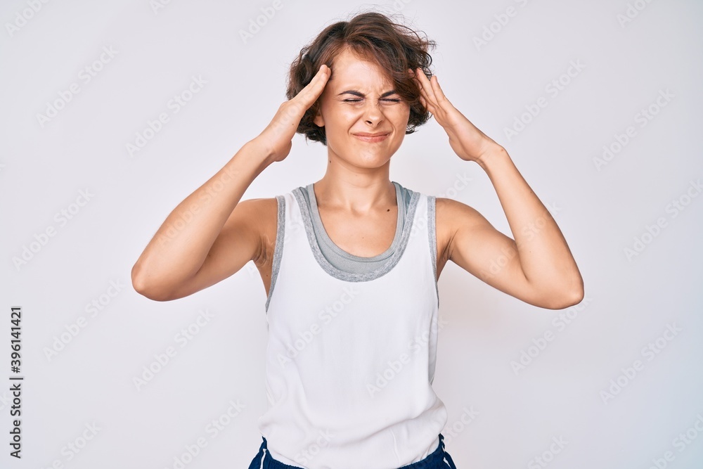 Young hispanic woman wearing sportswear suffering from headache desperate and stressed because pain and migraine. hands on head. Young hispanic woman wearing sportswear suffering from headache desperate and stressed because pain and migraine. hands on head.