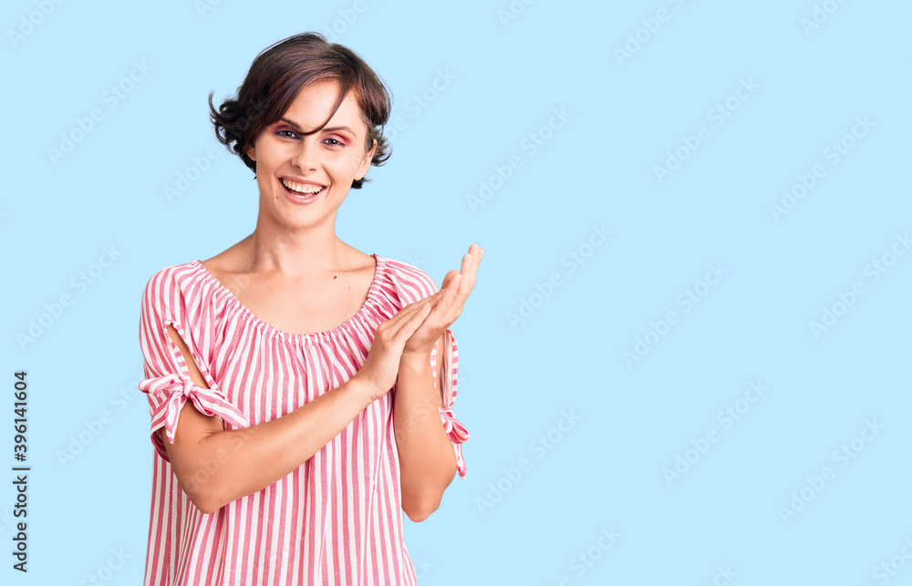 Beautiful young woman with short hair wearing casual summer clothes clapping and applauding happy and joyful, smiling proud hands together Beautiful young woman with short hair wearing casual summer clothes clapping and applauding happy and joyful, smiling proud hands together