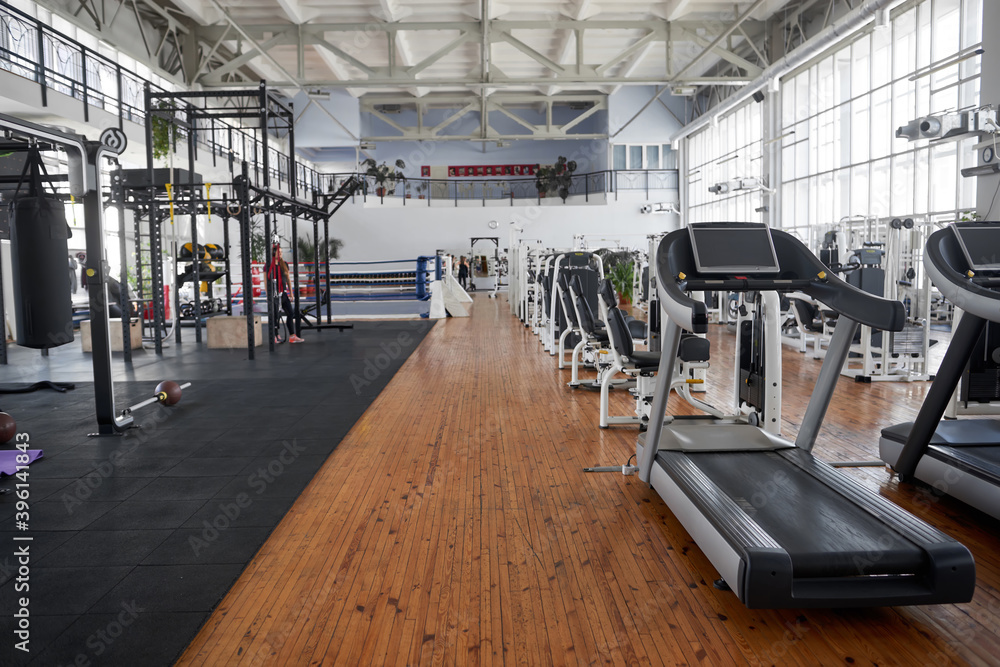 Fototapeta premium Gym interior with equipment. Treadmills for fitness cardio training. Sport club for fitness workout.