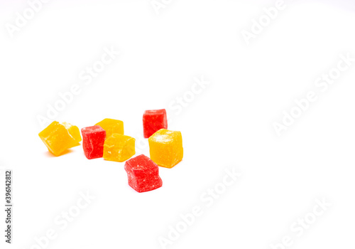 Cubes of appetizing orange and red rahat Turkish delight on a white background