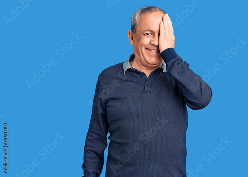 Canvastavla Senior handsome man wearing casual polo covering one eye with hand, confident smile on face and surprise emotion