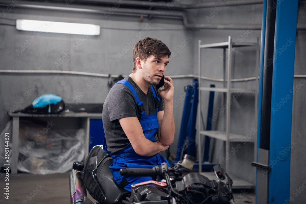 A machinist talking to a client on the phone about a motorcycle