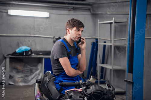 A machinist talking to a client on the phone about a motorcycle