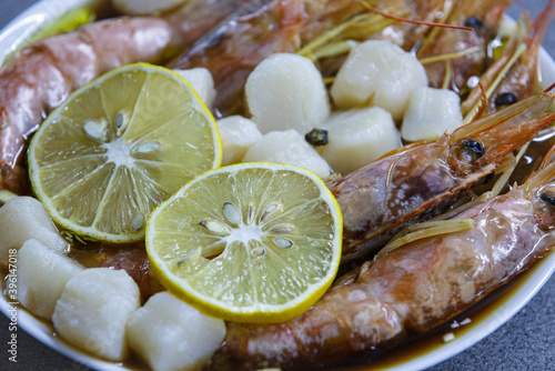 shrimp and scallop in lemons and soy sauce on a white plate