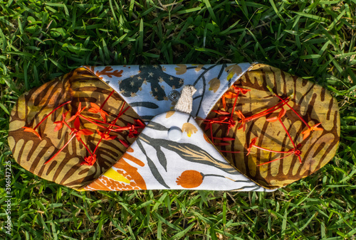 Washable menstrual cloth pads with flower petals symbolizing woman's period on grass. Reusable eco-friendly feminine hygiene products. Zero waste sustainable plastic free lifestyle